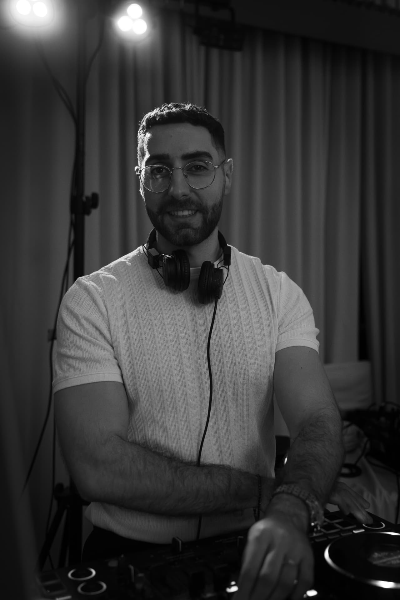 Leende DJ med hörlurar vid mixern