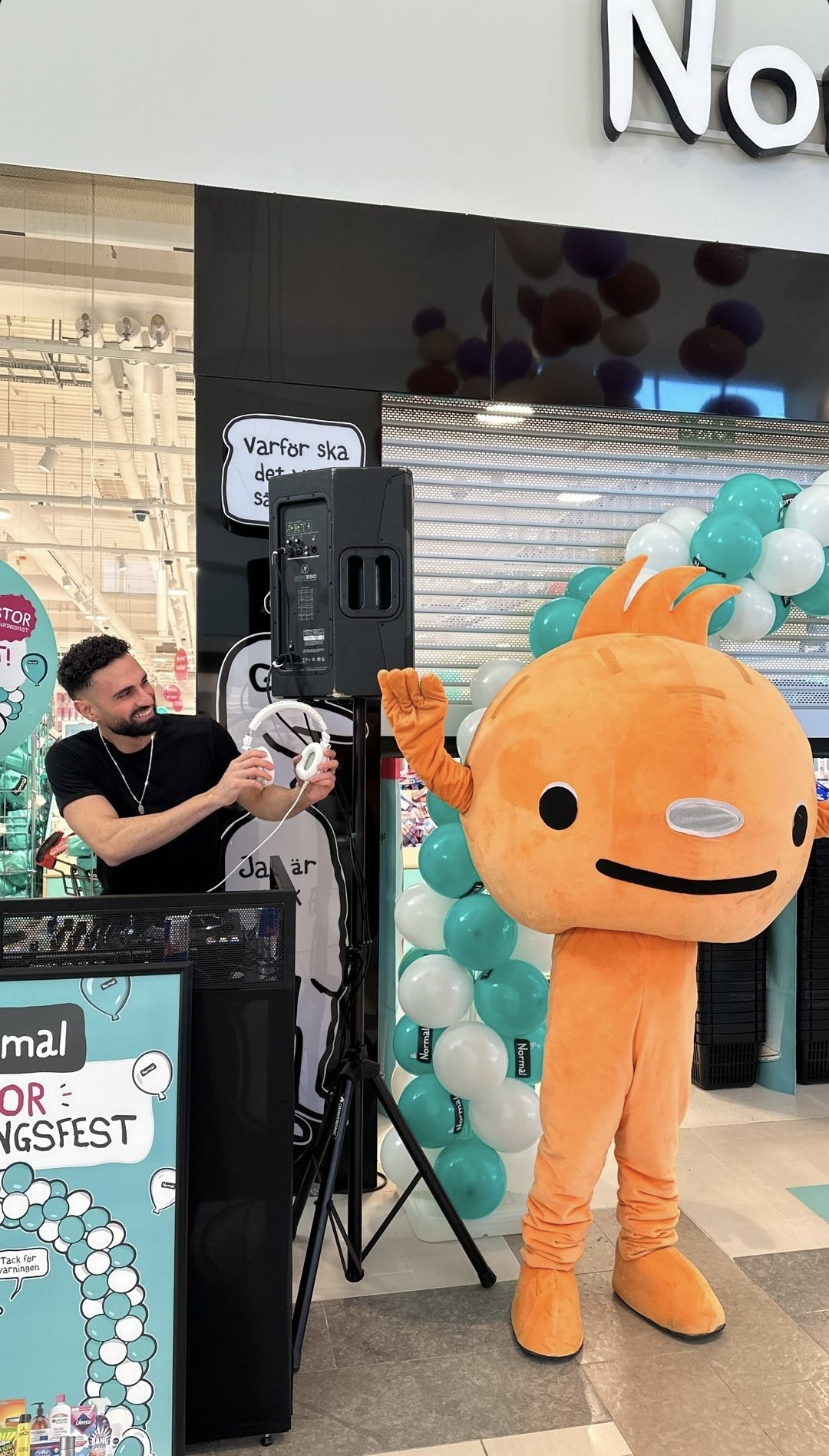 DJ med maskotten och ljudanläggning på butiksinvigning