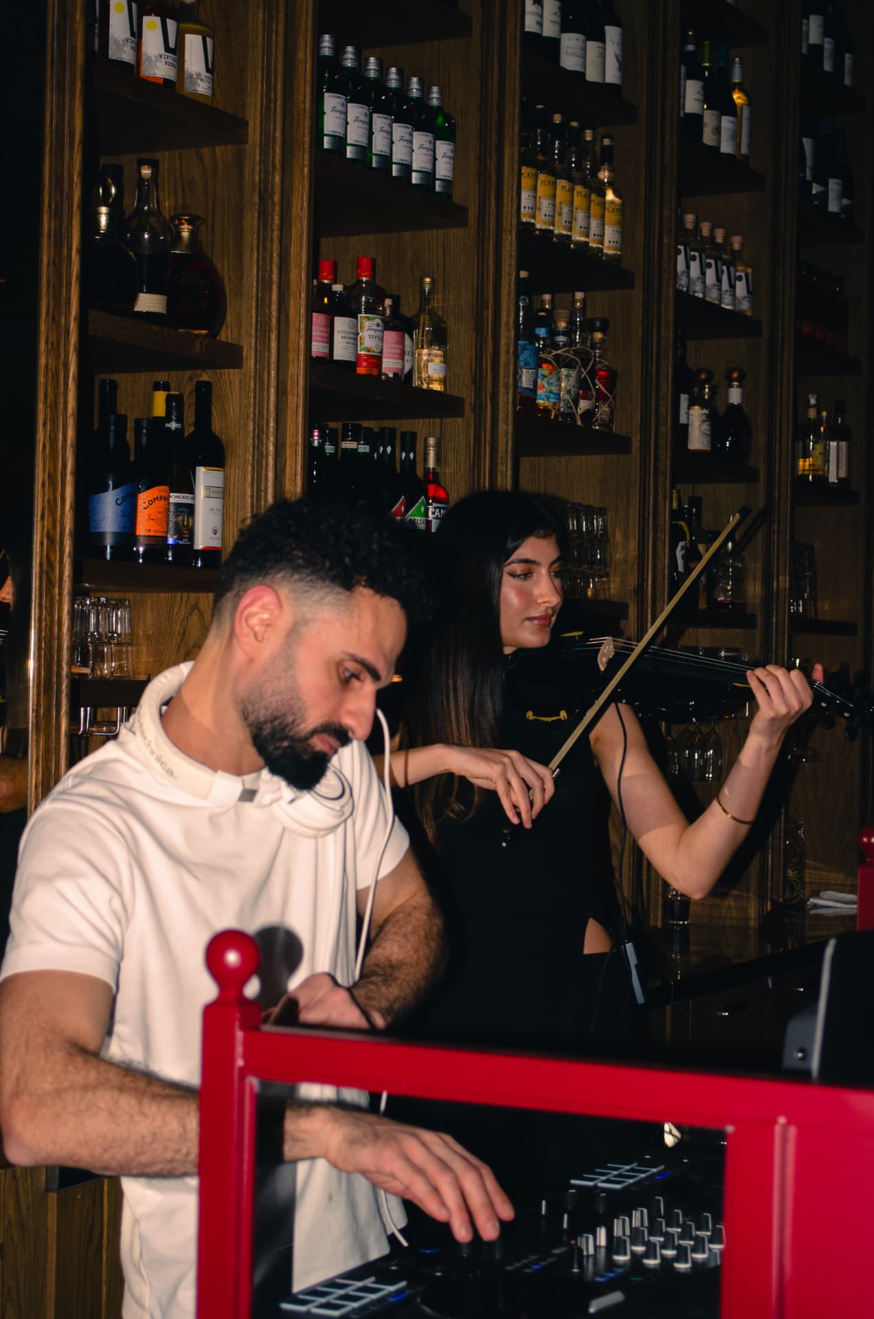 DJ och violinist uppträder framför baren