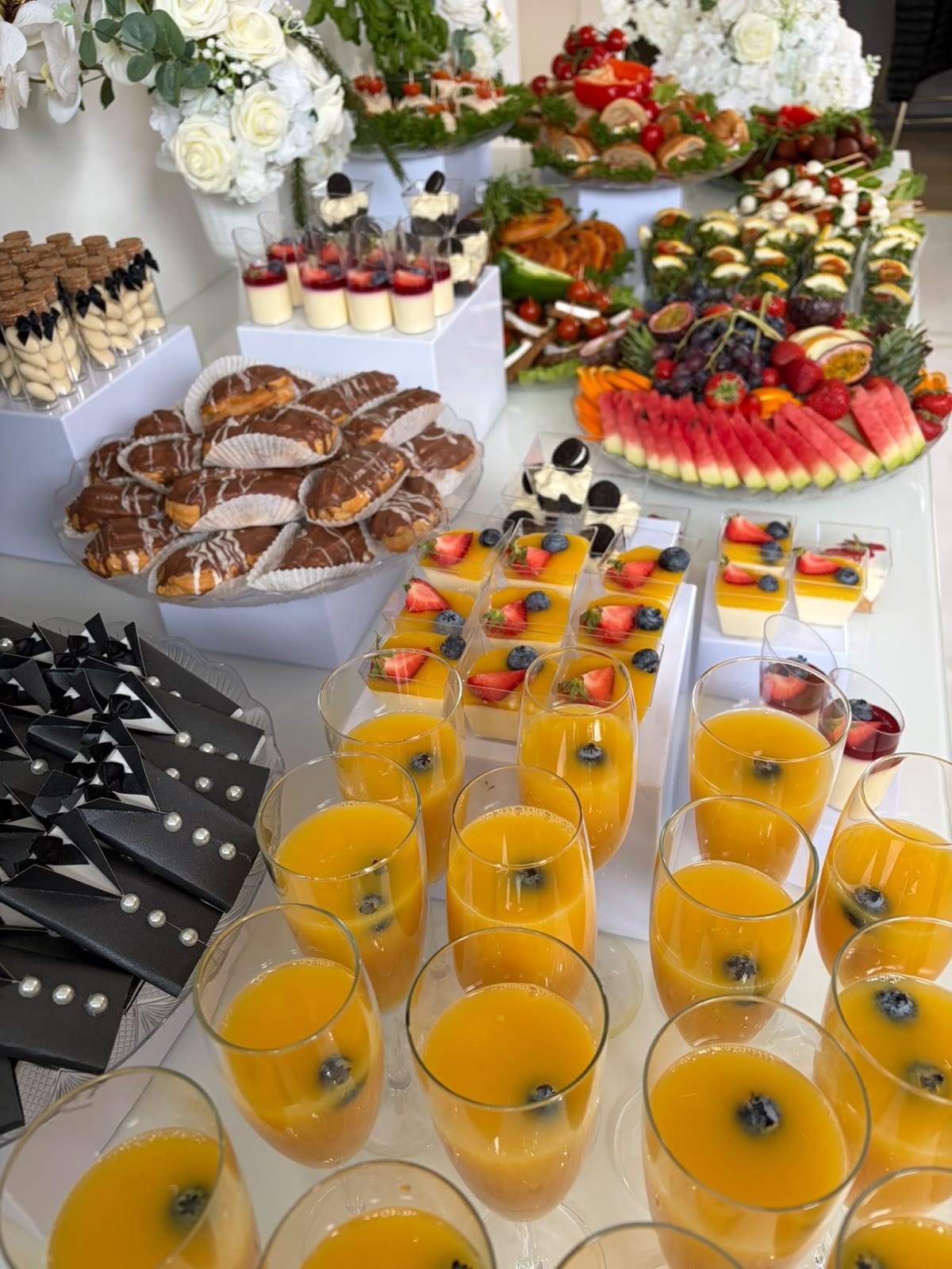 Dessertbord med champagneglas, portionsdesserter och frukt